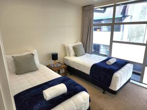 - une chambre avec 2 lits et une fenêtre dans l'établissement U Suites on Jessie, à Wellington