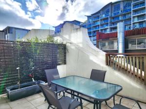 a patio with a table and chairs and a building at U Suites on Jessie in Wellington