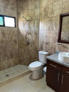 a bathroom with a toilet and a shower and a sink at Real Paraiso in Juticalpa