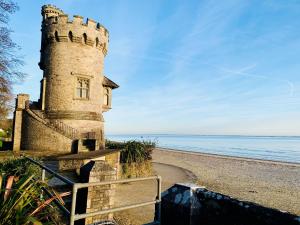 un faro en una playa con el océano en el fondo en Sundowners, en Ryde