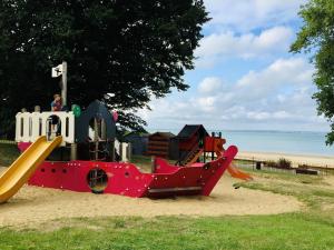 un parque infantil con un tobogán en la arena cerca de la playa en Sundowners en Ryde