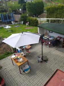 een witte parasol op een patio met tafels en stoelen bij U Pintovky in Tábor