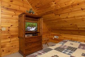 - une chambre avec une télévision dans une cabane en bois dans l'établissement Bearway to Heaven, à Sevierville