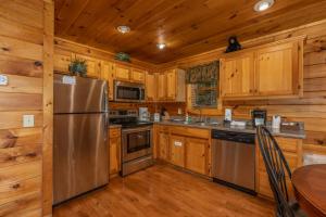uma cozinha com armários de madeira e um frigorífico de aço inoxidável em Bearway to Heaven em Sevierville