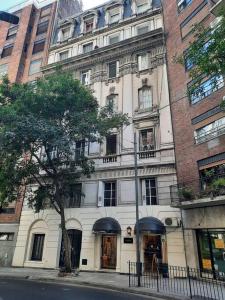 un gran edificio blanco con un árbol delante en Classic Quiet 1-Bdr in Recoleta en Buenos Aires
