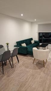 a living room with a green couch and a table and chairs at Luxury Apartment Birmingham in Birmingham