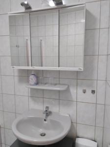 a white bathroom with a sink and a mirror at Ferienwohnung Zülpich Seenähe in Zülpich