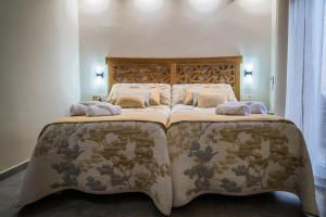 1 dormitorio con 1 cama grande y 2 almohadas en Apartamentos Turísticos El Altozano, en Fuentes de León