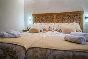 dos camas sentadas una al lado de la otra con almohadas en Apartamentos Turísticos El Altozano, en Fuentes de León