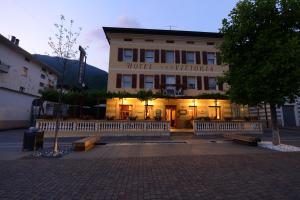 a hotel with benches in front of a building at Hotel Vittoria in Levico Terme