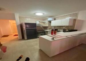 un soggiorno con un divano bianco e una cucina di شاليه 3 غرف قريه بلومار الدوم عائلات للإقامة يطلب موافقه امنيه قبل 48 ساعه من الاقامه - توجد مصاريف لبوابة القرية - استهلاك الكهرباء على العميل a Ain Sokhna