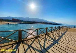 una recinzione di legno accanto a un corpo idrico di شاليه 3 غرف قريه بلومار الدوم عائلات للإقامة يطلب موافقه امنيه قبل 48 ساعه من الاقامه - توجد مصاريف لبوابة القرية - استهلاك الكهرباء على العميل a Ain Sokhna