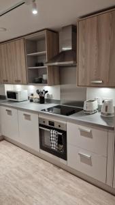 a kitchen with wooden cabinets and a stove top oven at Luxury Apartment Birmingham in Birmingham