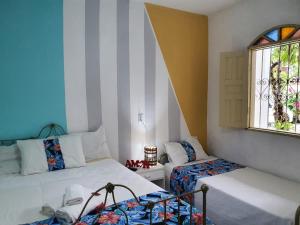 um quarto com duas camas e uma janela em Pousada Sonho Meu em Porto Seguro