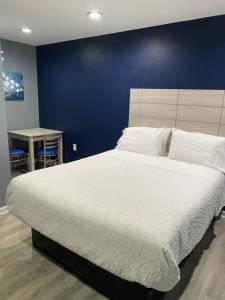 1 dormitorio con 1 cama grande y pared azul en Dunmore Inn en Dunmore