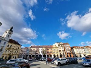 un grupo de edificios con coches estacionados en un estacionamiento en Podkrovní byt na Velkém náměstí s Wi-Fi zdarma en Hradec Králové