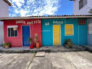 Pousada Sonho Meu في بورتو سيغورو: مبنى أمامه أبواب ملونة ونباتات