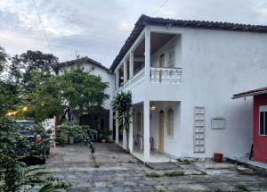 a white house with a balcony and a driveway at Pousada Sonho Meu in Porto Seguro