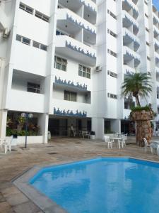 a hotel with a swimming pool in front of a building at Hotel Jalim in Caldas Novas