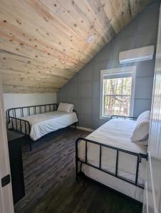 twee bedden in een kamer met een houten plafond bij Hillside Hangout 3Bd/2Ba, Elevated Deck Sunsets in Pinetop-Lakeside
