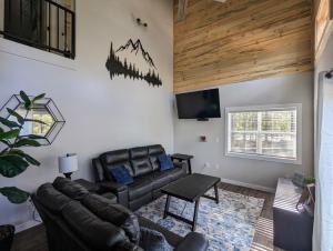 een woonkamer met een leren bank en een tv bij Hillside Hangout 3Bd/2Ba, Elevated Deck Sunsets in Pinetop-Lakeside
