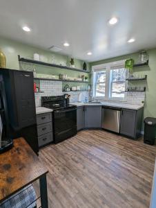 a kitchen with green walls and wooden floors at Pinetop Getaway w Sunset Deck & Fire Pit Table in Pinetop-Lakeside