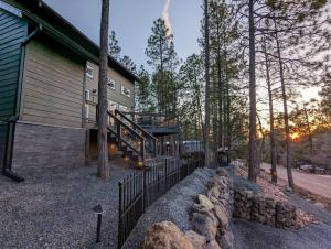 een huis in het bos met een hek bij Hillside Hangout 3Bd/2Ba, Elevated Deck Sunsets in Pinetop-Lakeside