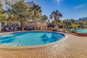 a swimming pool at a resort with palm trees at The Grand #2703 in Destin