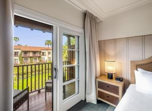 a hotel room with a bed and a balcony at Estancia La Jolla Hotel & Spa in San Diego