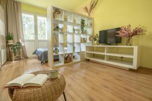 a living room with a television and a table with books at Apartament Premium Salt in Wieliczka
