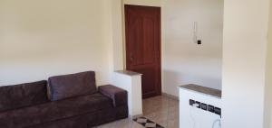 ein Wohnzimmer mit einem braunen Sofa und einer Tür in der Unterkunft appartement meublé avec wifi in Safi