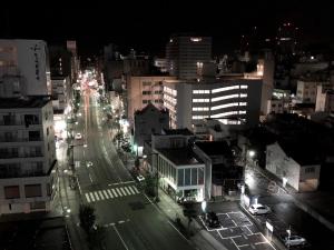 une rue de la ville la nuit avec des bâtiments et des lumières dans l'établissement APA Hotel Kanazawa Katamachi, à Kanazawa