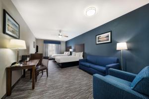 a hotel room with a bed and a couch and chairs at Best Western Plus Lake Dallas Inn & Suites in Lake Dallas