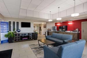 een woonkamer met 2 banken en een tv bij SureStay Hotel by Best Western Higginsville in Higginsville
