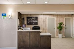 een kantoorlobby met een balie en een potplant bij SureStay Hotel by Best Western Higginsville in Higginsville