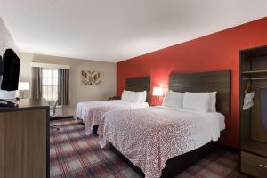 2 bedden in een hotelkamer met rode muren bij SureStay Hotel by Best Western Higginsville in Higginsville +24 foto's