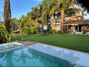 a swimming pool in front of a house with a yard at Jardín Quinta Las Fuentes Cabañas, Valsequillo. PUEBLA in Puebla
