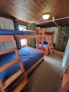 a room with three bunk beds in a cabin at Two Rivers Motel and Cabins 