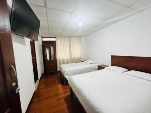 a hotel room with two beds and a television at OROSHEAM in Arequipa