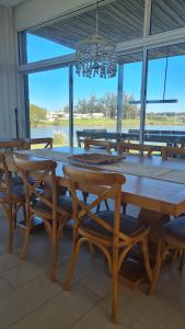 uma sala de jantar com uma grande mesa de madeira e cadeiras em Ventarrón Pueblomio Manantiales em Manantiales