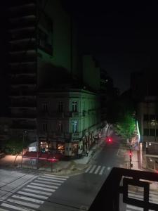 una calle de ciudad vacía por la noche con un edificio en Residencia estudiantes Recoleta en Buenos Aires