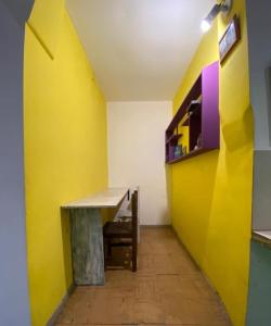 Habitación con mesa y pared amarilla en Residencia estudiantes Recoleta en Buenos Aires