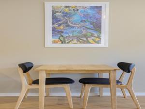 uma mesa com duas cadeiras e um quadro na parede em Eagle Heights Holiday Units em Eden