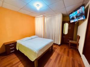 sypialnia z łóżkiem i telewizorem z płaskim ekranem w obiekcie OROSHEAM w mieście Arequipa