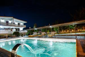 ein Pool in der Nacht mit einem Hotel in der Unterkunft Villa Mairi in Salamís