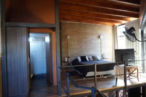 ein Schlafzimmer mit einem Bett und einer Ziegelwand in der Unterkunft Loft Lomas Del Suquia in Cordoba