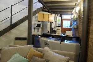 ein Wohnzimmer mit einem Sofa und einer Küche in der Unterkunft Loft Lomas Del Suquia in Cordoba
