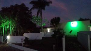 a green light on the side of a house at night at Lagos Suítes in Guapé