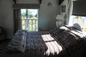 a bedroom with a large bed with a large window at Brockies B n B in Rawene