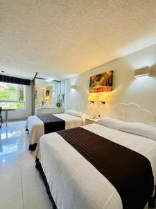 una habitación de hotel con 3 camas en una habitación en Hotel Plaza Caribe, en Cancún